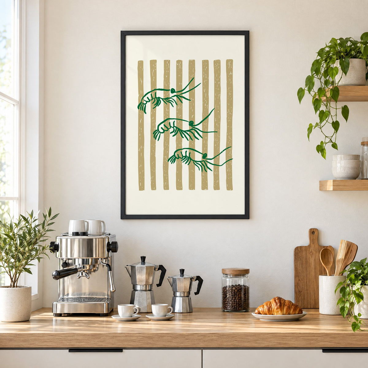 Three green shrimp on gold stripes print in a black frame above a home espresso bar with moka pots and espresso cups
