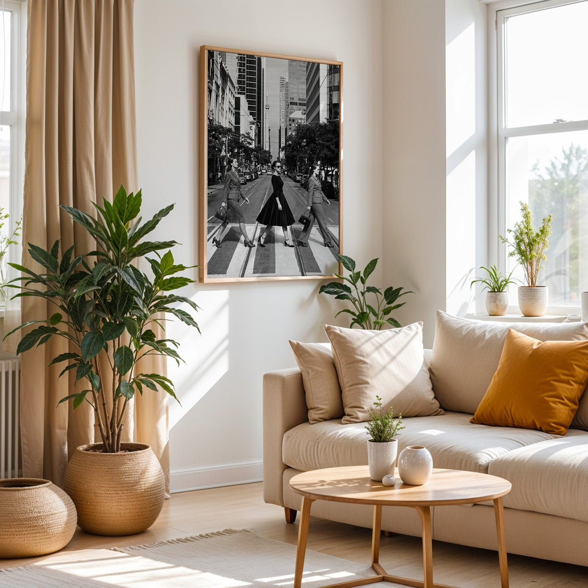 Three women crossing a city street print in an oak frame above a cream sofa beside woven planters