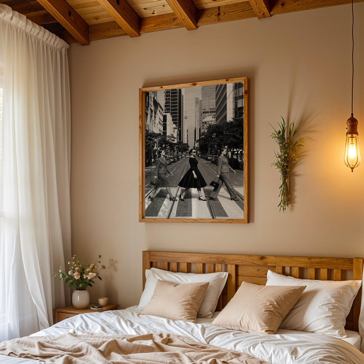 Three women crossing a city street print in a pine frame above a wood headboard bed under a pendant bulb