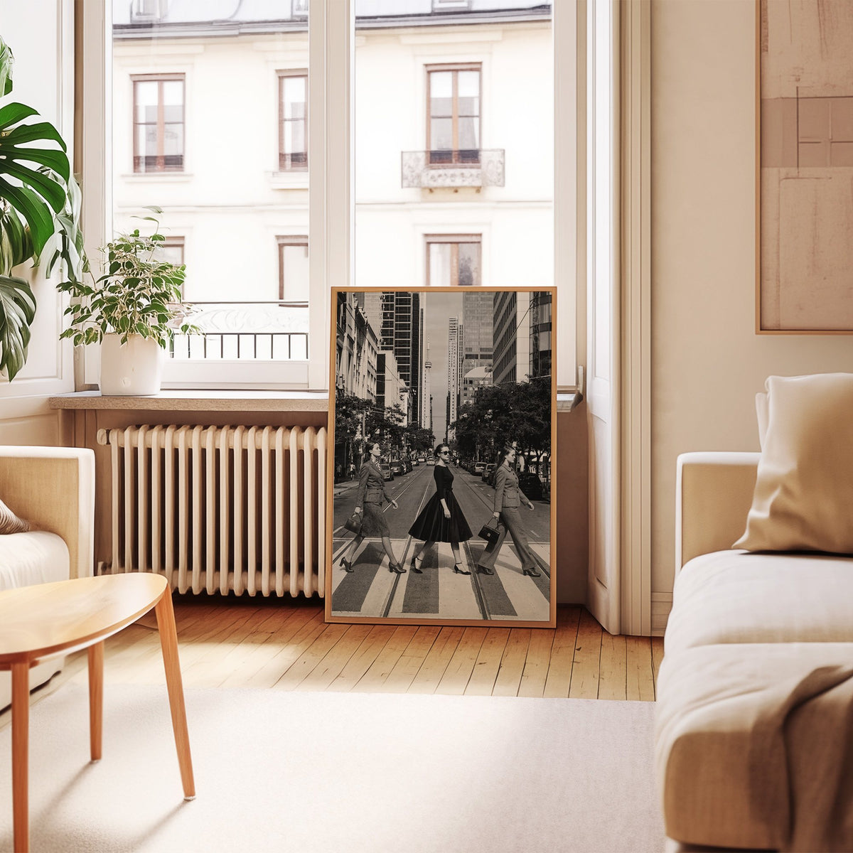 Three women crossing a city street print in an oak frame leaning by a French window in a living room