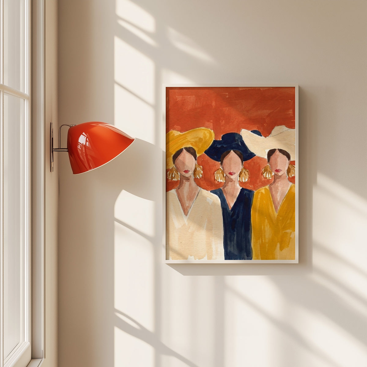 Three women in wide brim hats print in a white frame beside a red wall sconce