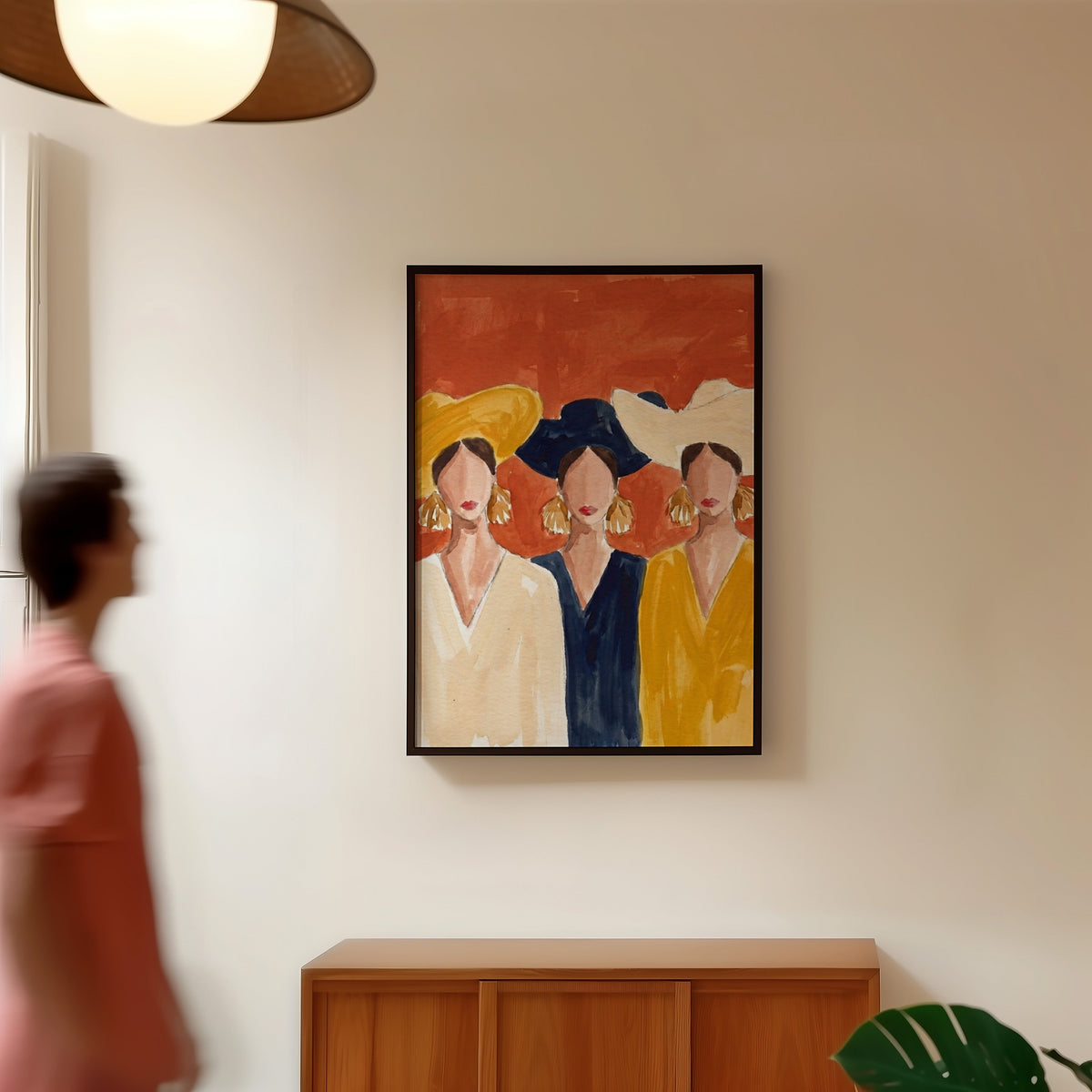 Three friends fashion print in a black frame in a hallway under a rattan pendant
