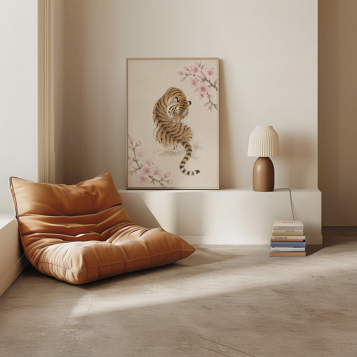 resting tiger with cherry blossom print in a light oak frame on a white ledge by a tan leather floor chair