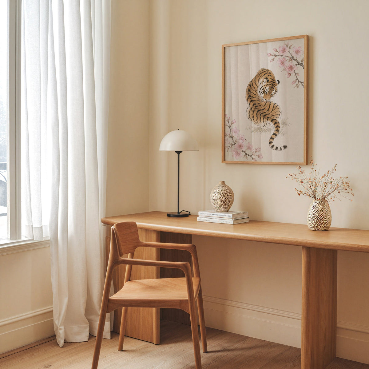 resting tiger with cherry blossom print in an oak frame above a long oak desk with a white dome lamp and woven vases
