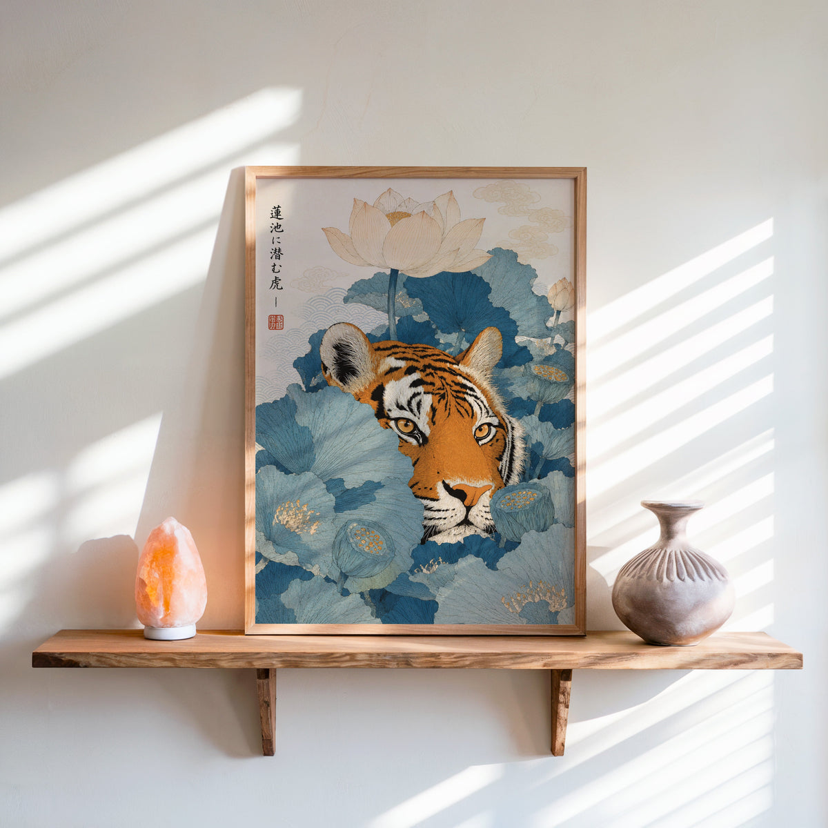 tiger hiding in blue lotus leaves print in an oak frame on a live-edge wall shelf with a salt lamp and clay vase
