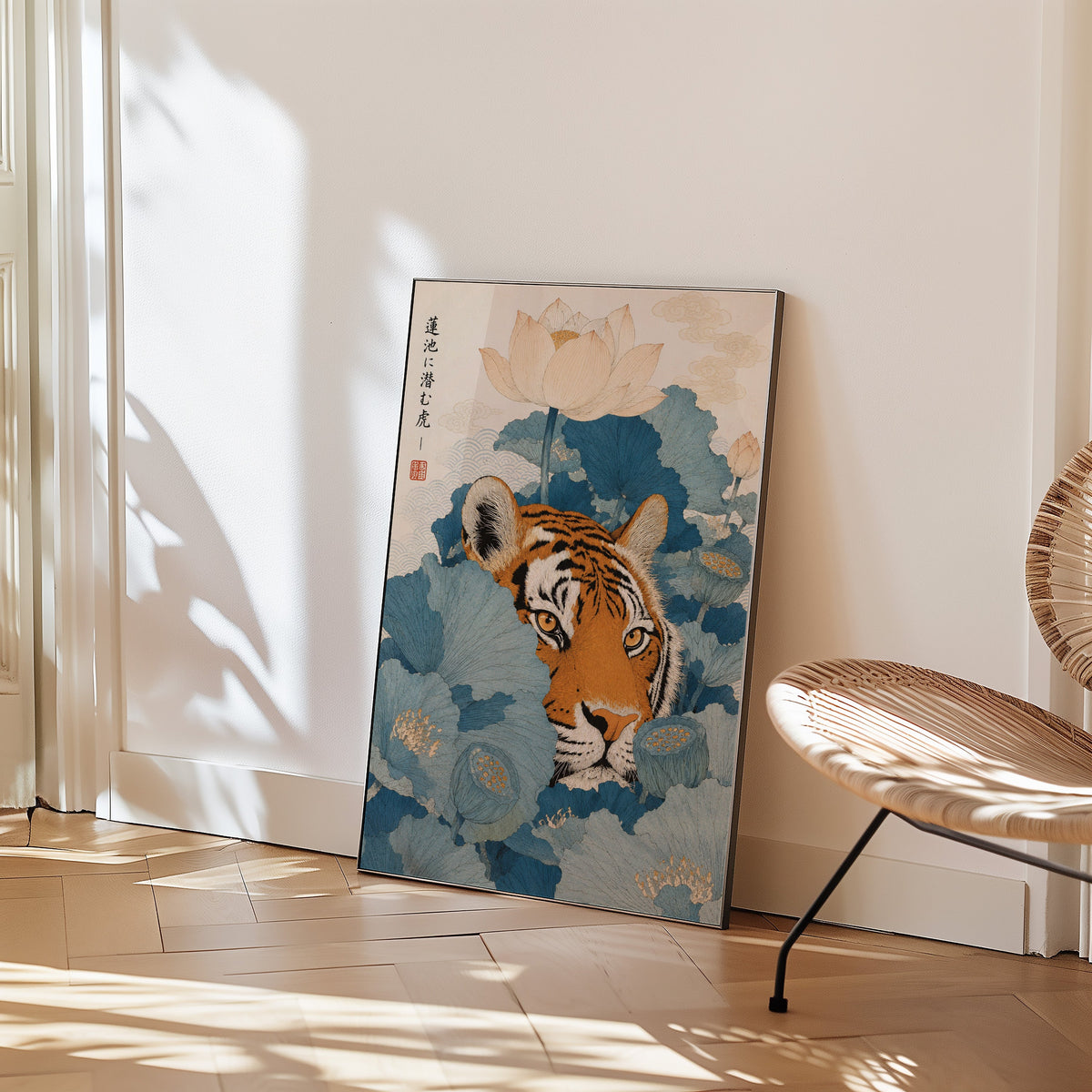 tiger hiding in blue lotus leaves print in a black frame leaning on a herringbone floor beside a woven rattan chair