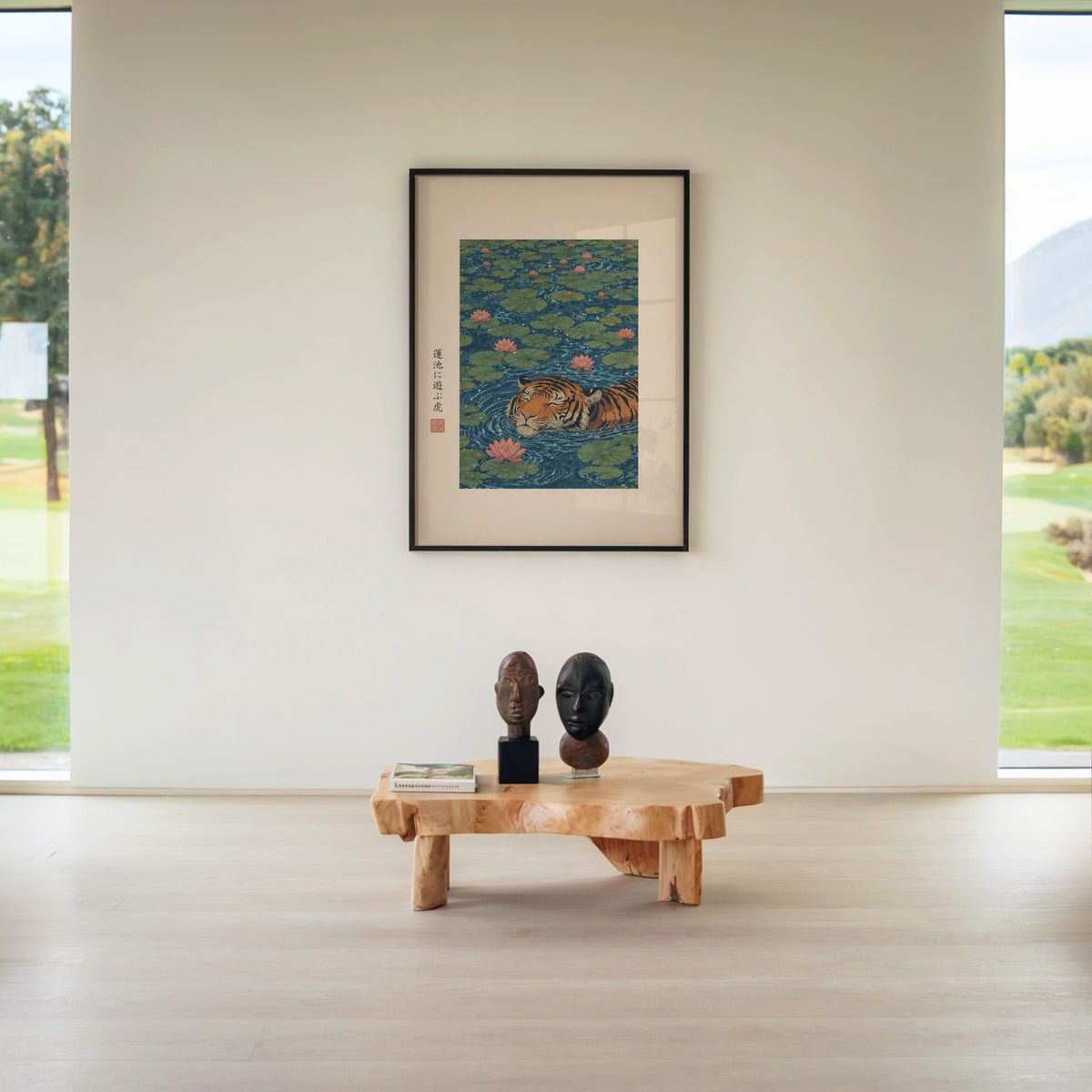 tiger swimming in lotus pond print in a black frame above a live-edge wood coffee table between garden windows