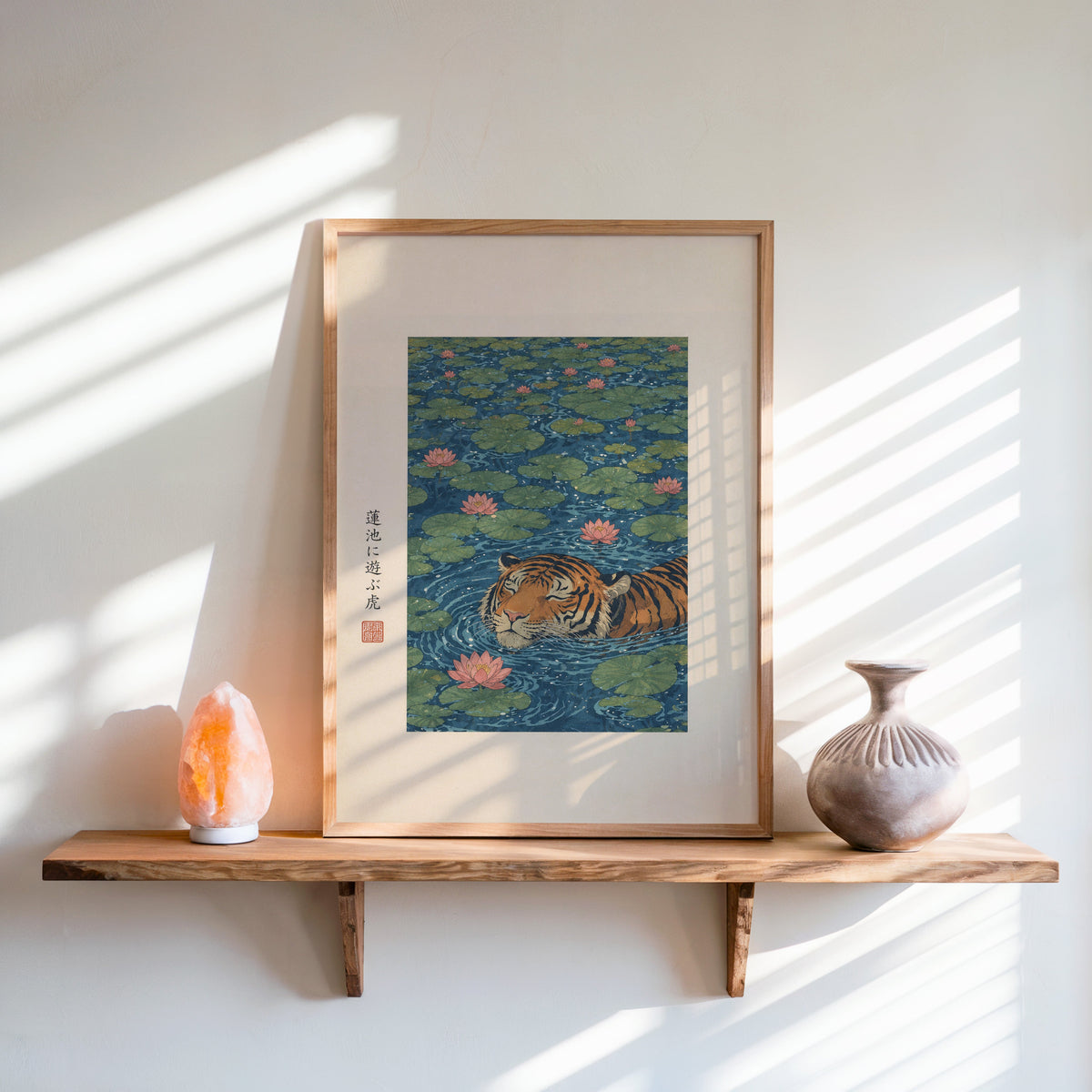 tiger swimming in lotus pond print in an oak frame on a live-edge wall shelf with a salt lamp and clay vase
