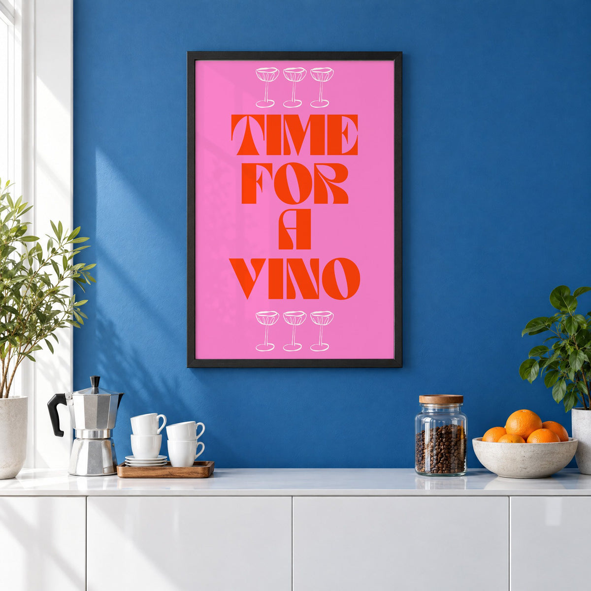 Time for a Vino pink coupes print in a black frame on a cobalt blue wall above a coffee station