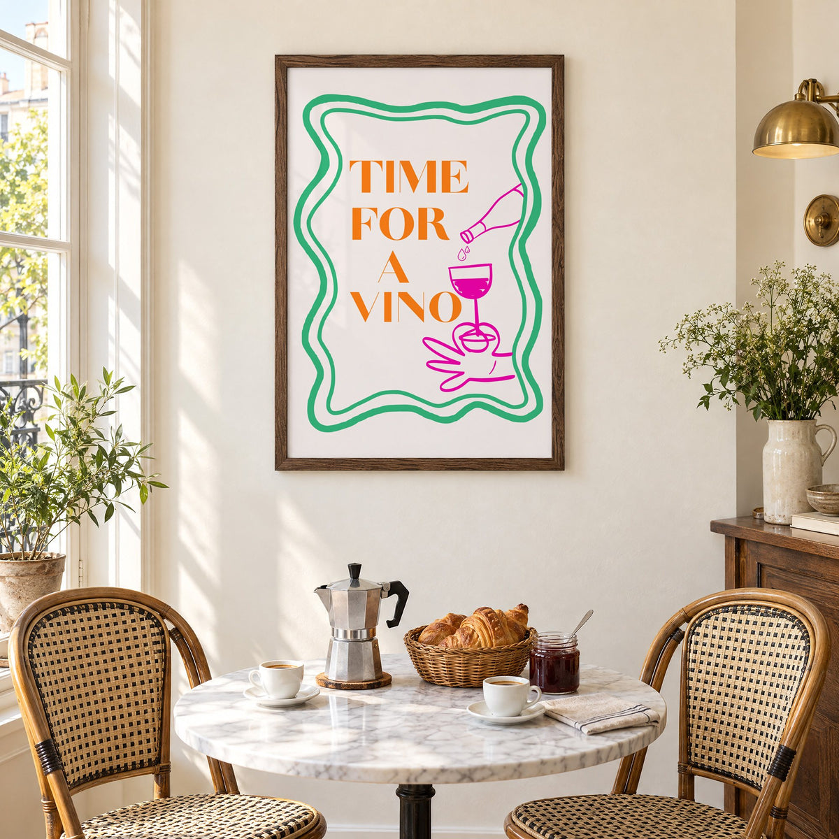 TIME FOR A VINO wine pour wavy frame print in a walnut frame above a marble bistro table with croissants and rattan chairs
