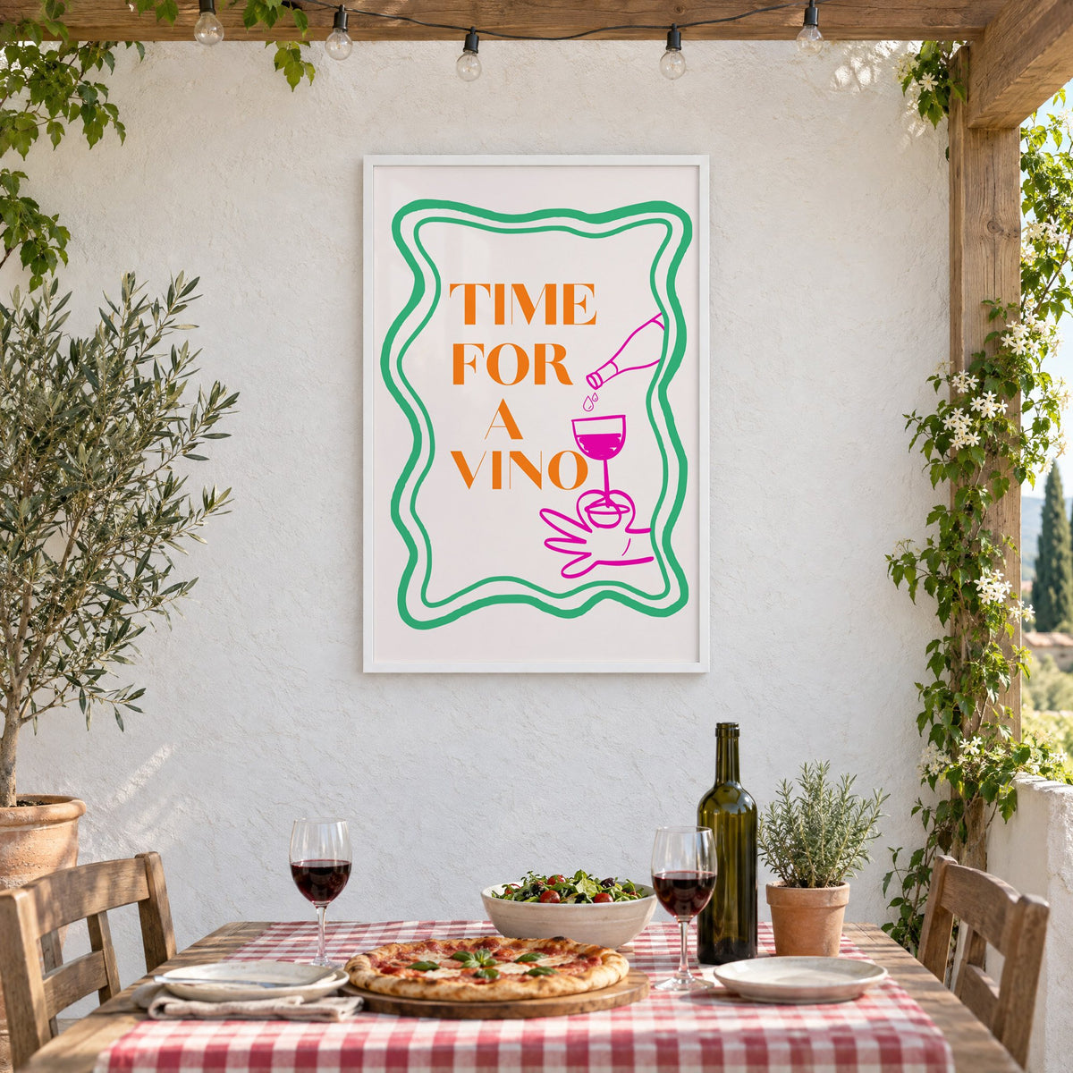 TIME FOR A VINO wine pour wavy frame print in a white frame on a stucco wall above a checked-cloth table with pizza and red wine