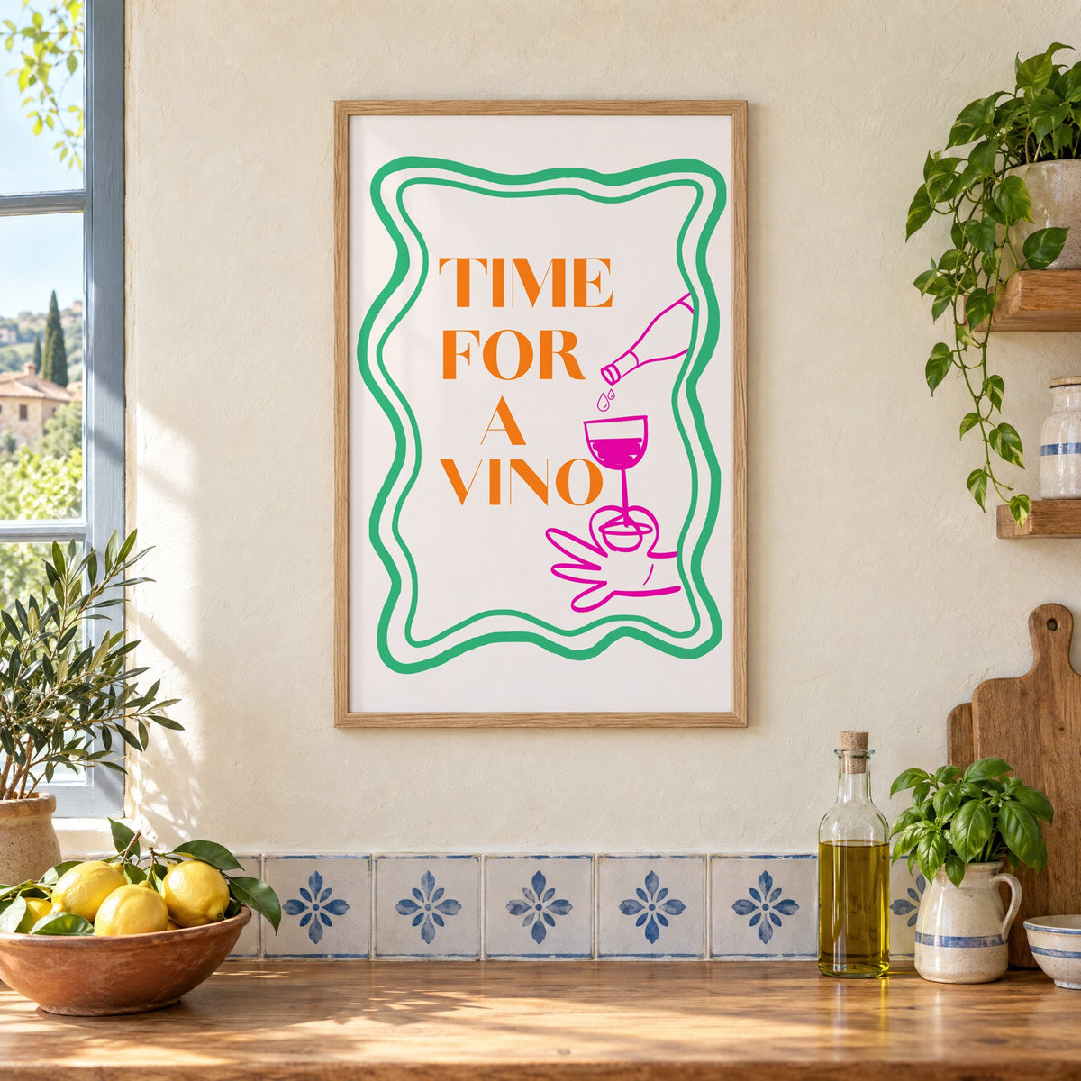 TIME FOR A VINO wine pour wavy frame print in an oak frame on a cream plaster wall above a worktop with a bowl of lemons and blue-and-white tiles