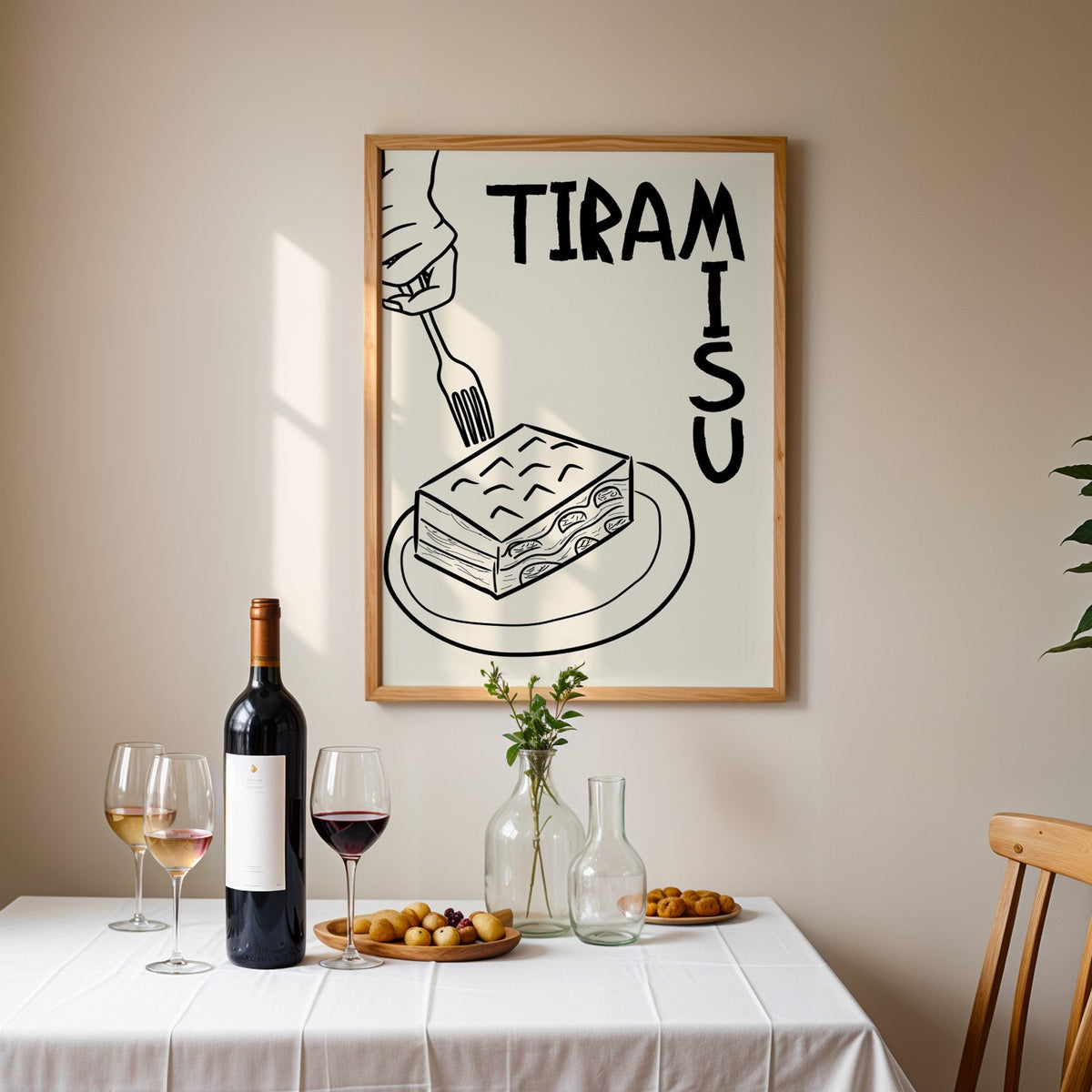 Tiramisu line art print in an oak frame above a table laid with red wine and glasses
