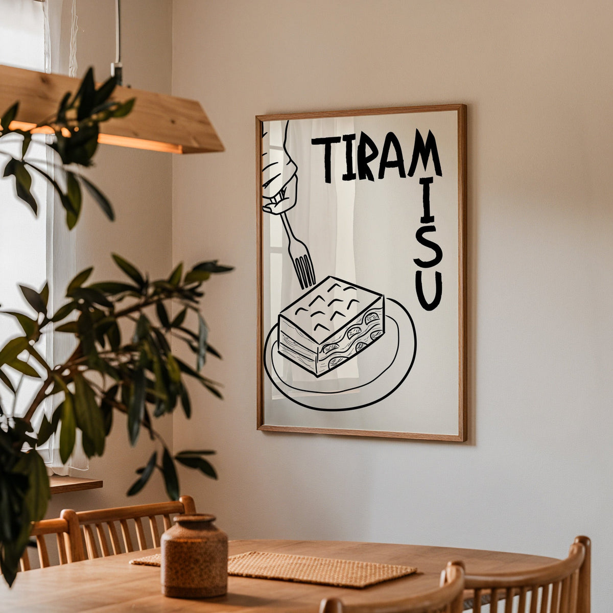 Tiramisu line art print in a walnut frame above a dining table beside an olive tree