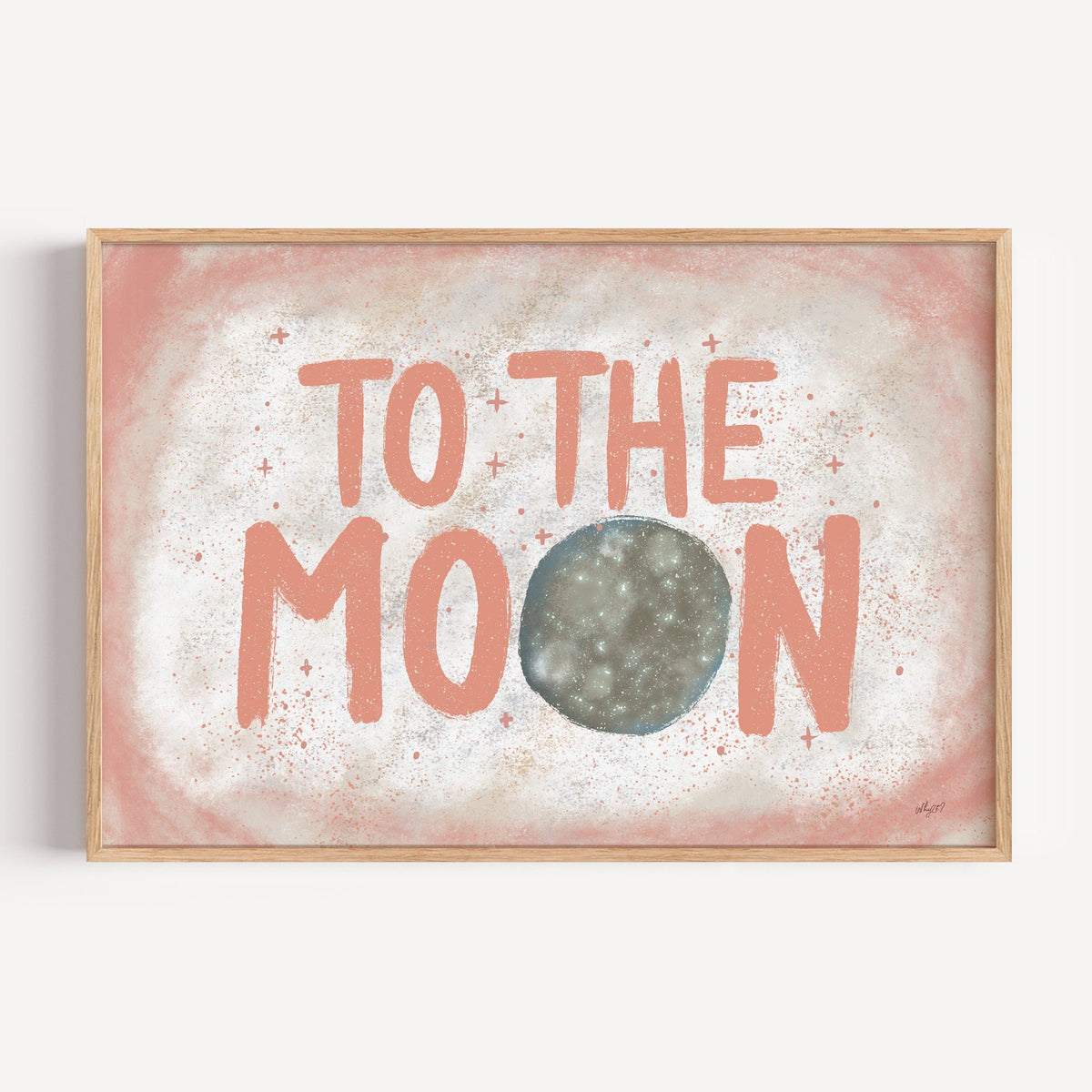 To the moon coral lettering nursery print in a light oak frame on a plain white wall