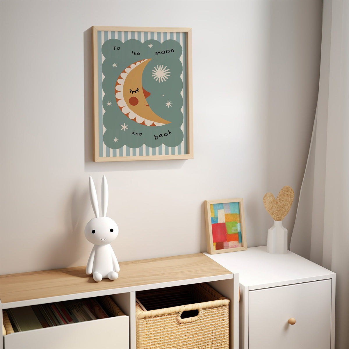 To the moon and back nursery print in an oak frame above a kids cubby shelf with a woven basket and bunny lamp