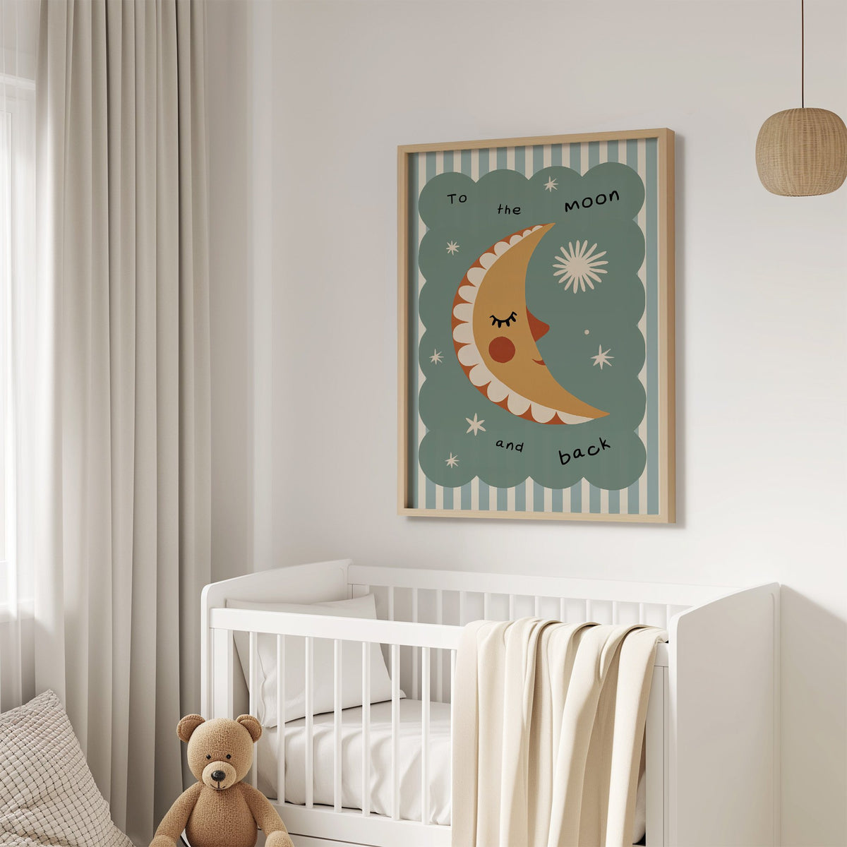 To the moon and back nursery print in an oak frame above a white crib with a teddy bear
