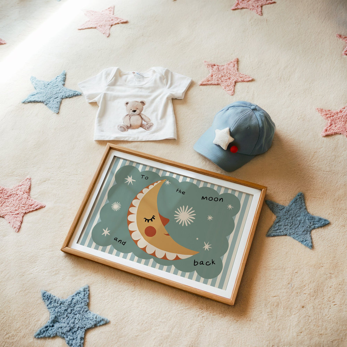 Landscape to the moon and back nursery print in a matted oak frame on a star rug with a baby tee
