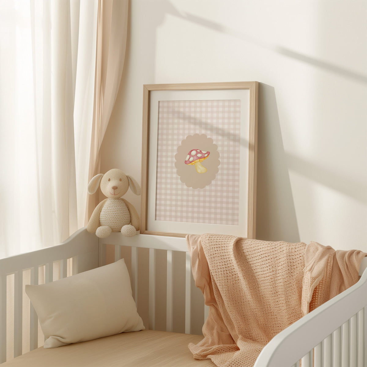 Pink spotted toadstool on beige gingham nursery print shown in an oak frame with a white mat on a crib rail