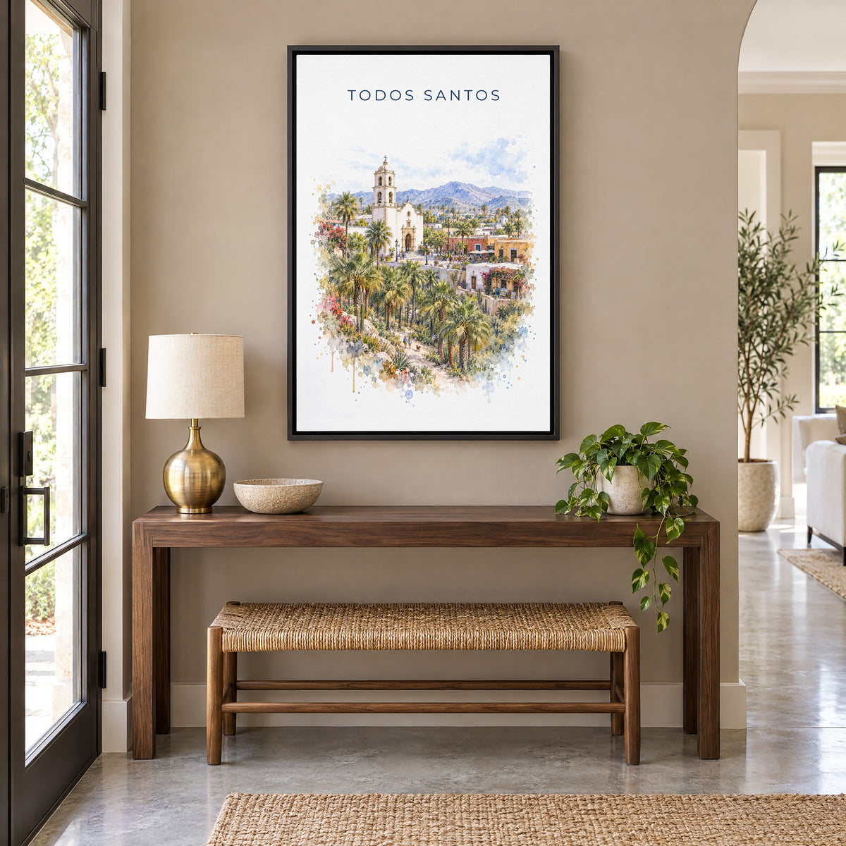 Todos Santos watercolor print as a black floater canvas above a walnut console and woven bench in an entryway