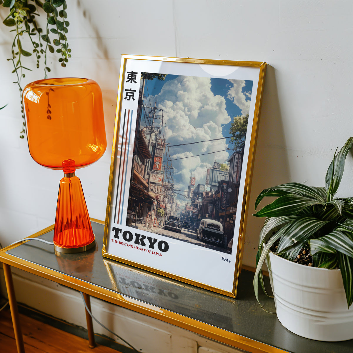 Vintage Tokyo 1944 street print shown in a gold frame on a console beside an orange glass lamp