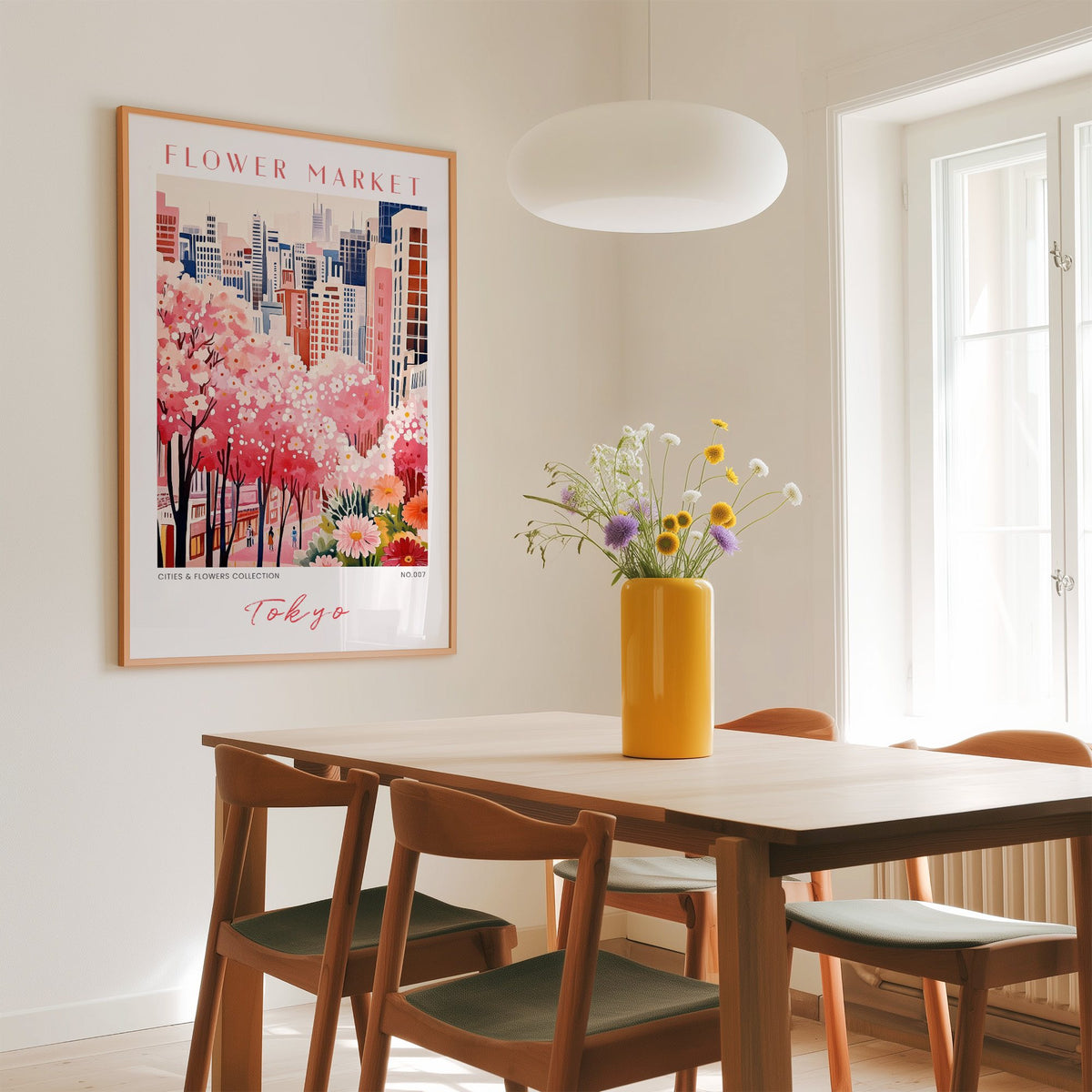 Tokyo flower market print in an oak frame above a dining table with a yellow vase and white pendant light