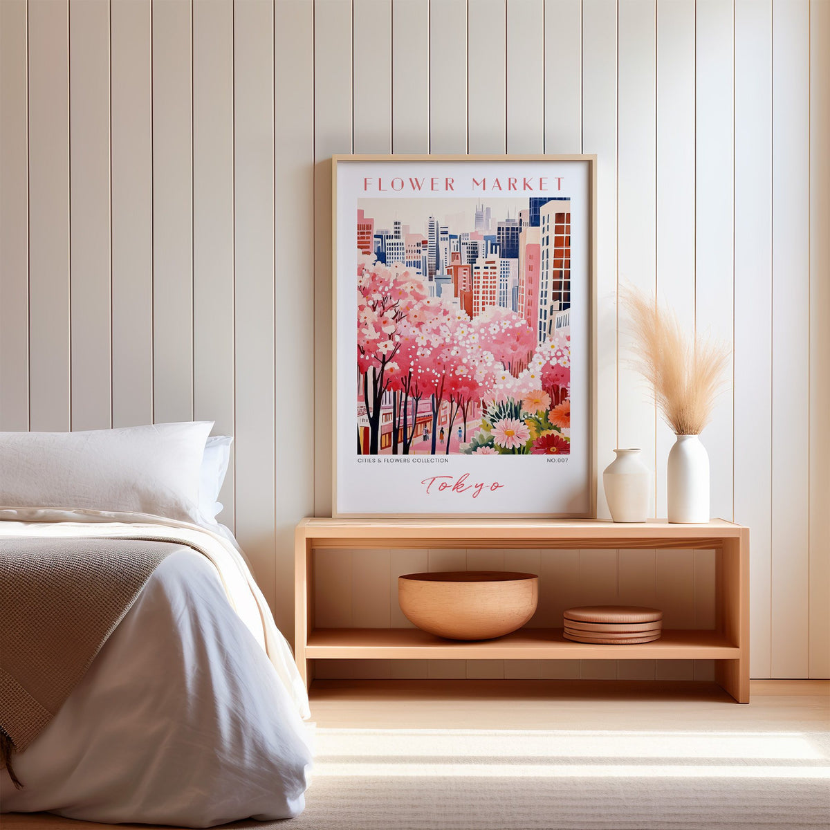 Tokyo flower market print in an oak frame on a wood bench against a white shiplap bedroom wall with pampas grass
