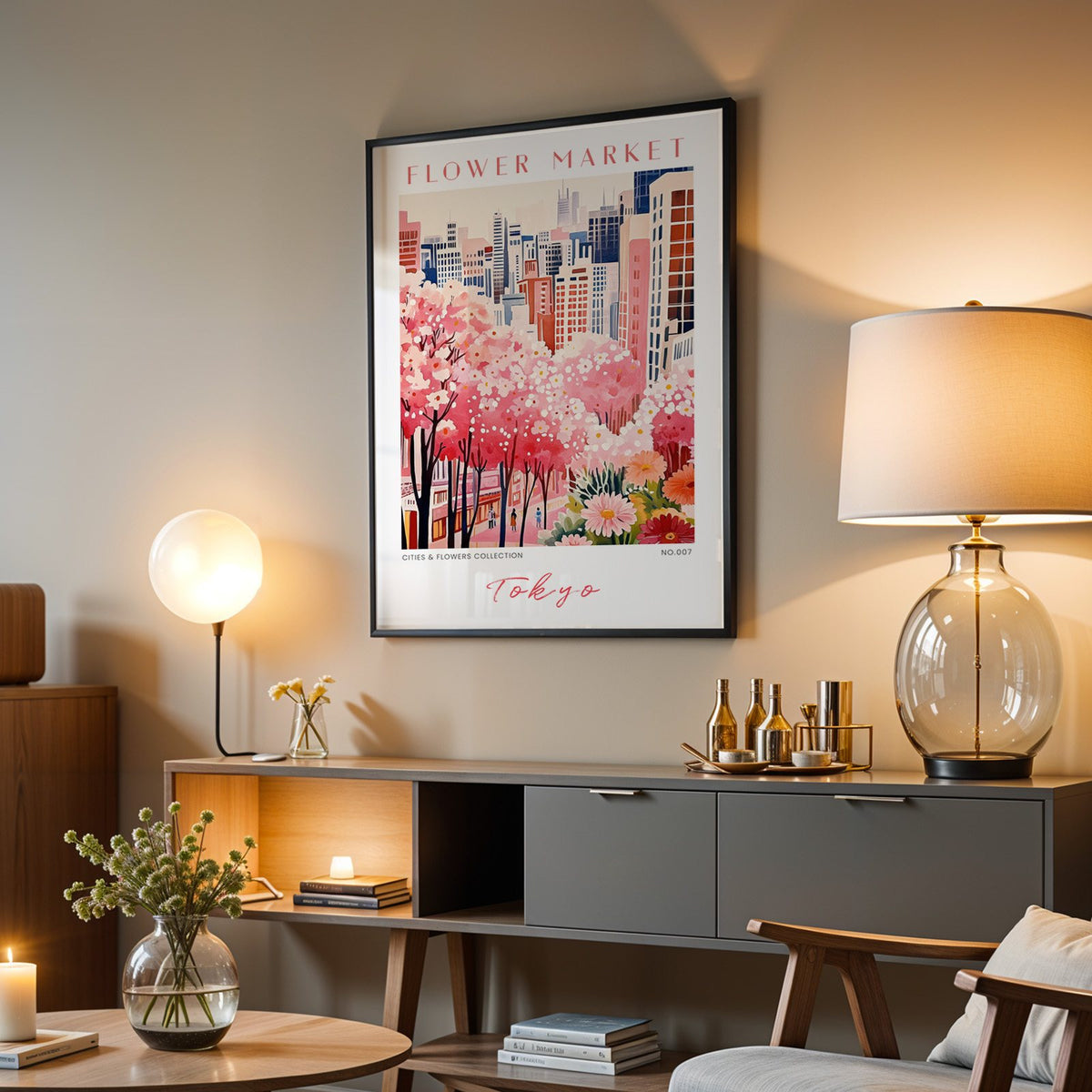 Tokyo flower market print in a black frame above a grey media console with a glass table lamp