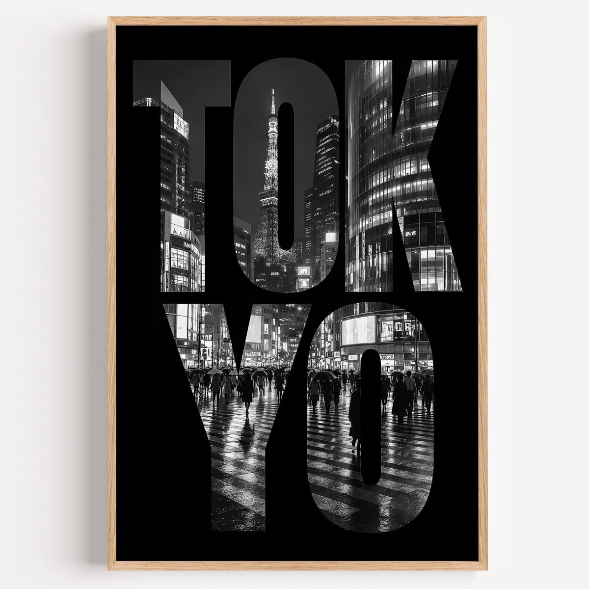Tokyo letters filled with night city photo print in a light oak frame on a plain white wall