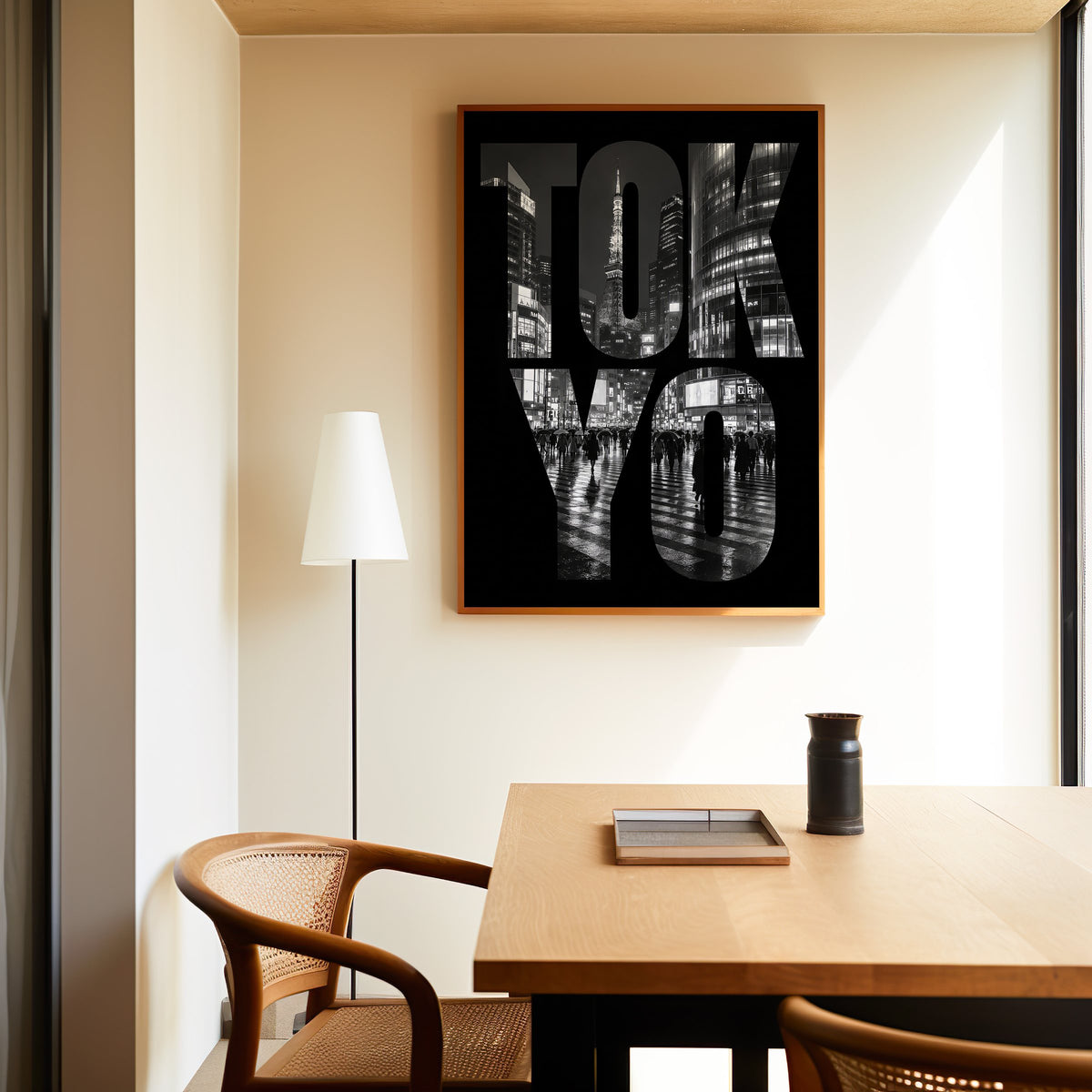 Tokyo letters filled with night city photo print in an oak frame above a dining table and cane chair