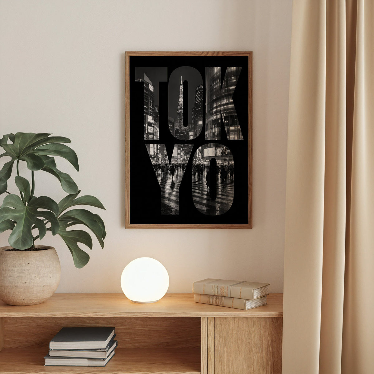 Tokyo letters filled with night city photo print in a walnut frame above an oak cabinet with a glowing globe lamp