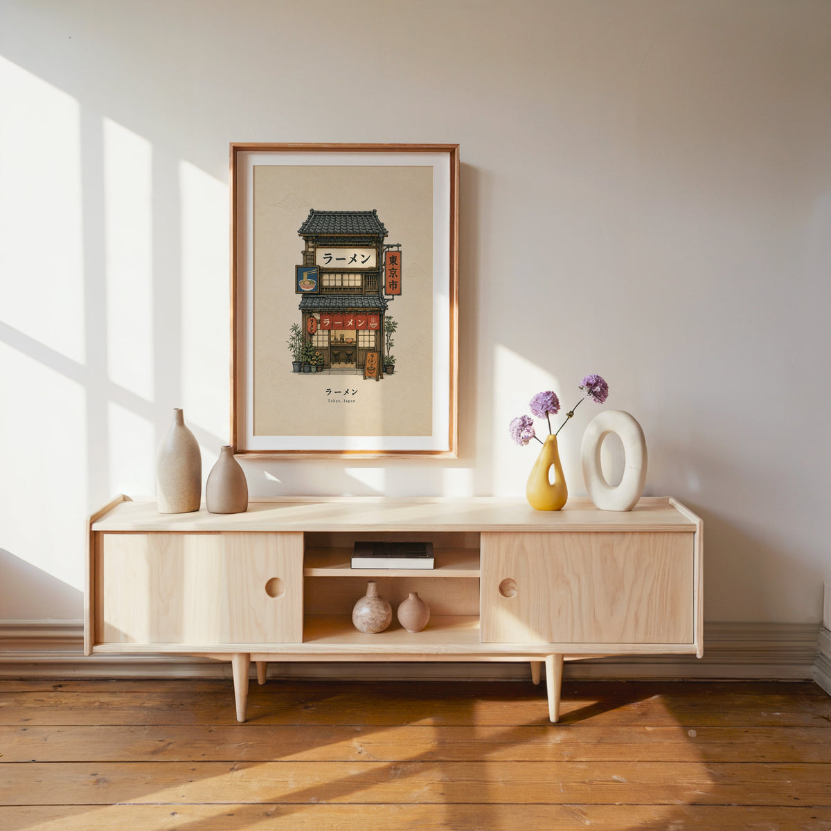 Tokyo ramen shop storefront print shown in a wood frame with a white mat above a pale wood media console