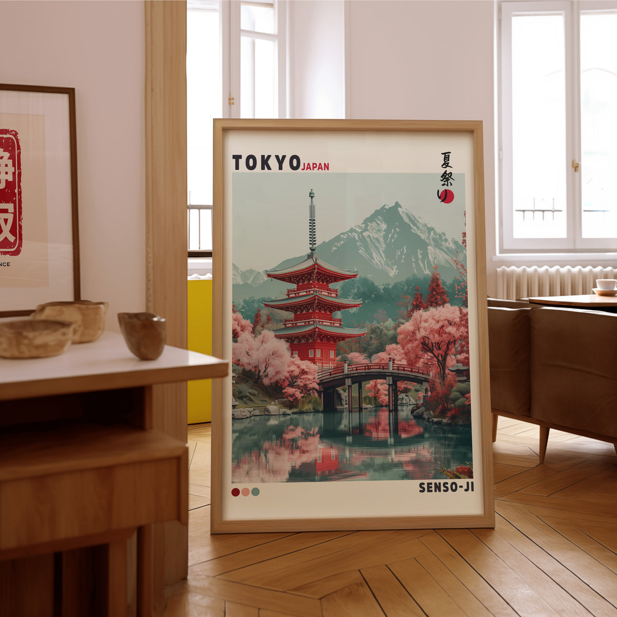 Red pagoda and arched bridge sakura print in an oak frame on the parquet floor of a sunlit living room
