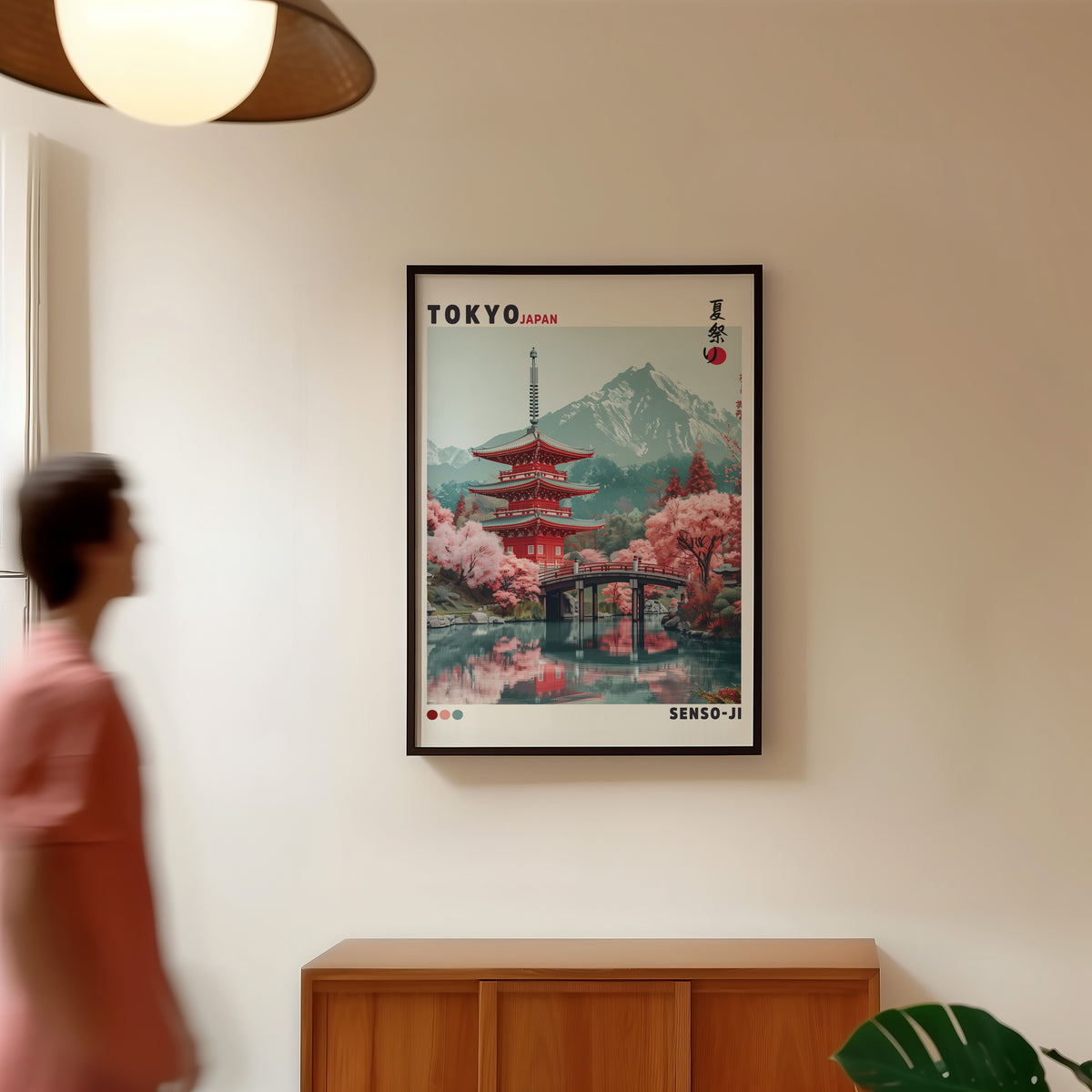 Red pagoda and arched bridge sakura print in a black frame in a hallway under a rattan pendant