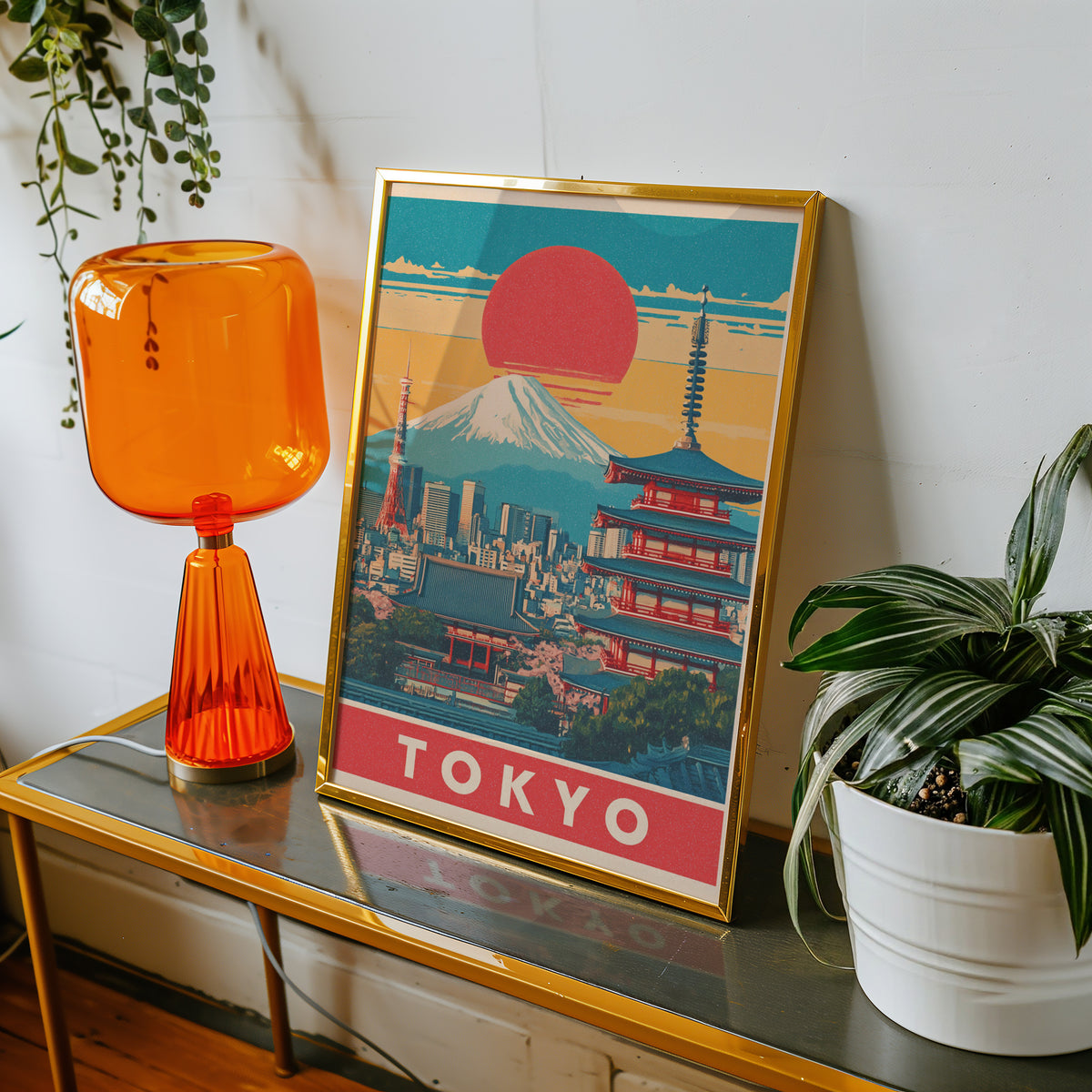 Retro Tokyo red sun skyline print shown in a gold frame on a console beside an orange glass lamp
