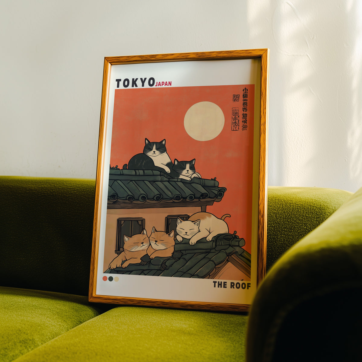 Five cats sleeping on Tokyo roof print in an oak frame propped on a green velvet sofa