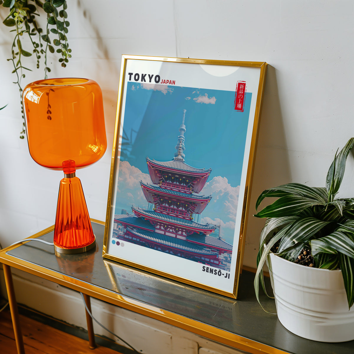 Senso-ji five-story pagoda print shown in a gold frame on a console beside an orange glass lamp