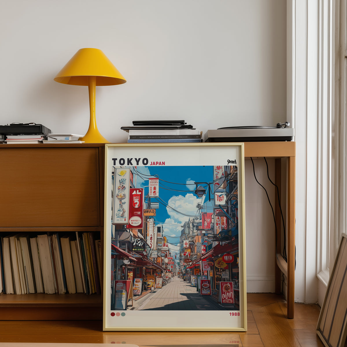 Tokyo shopping street 1988 print shown in a gold frame below a teak desk with a yellow lamp