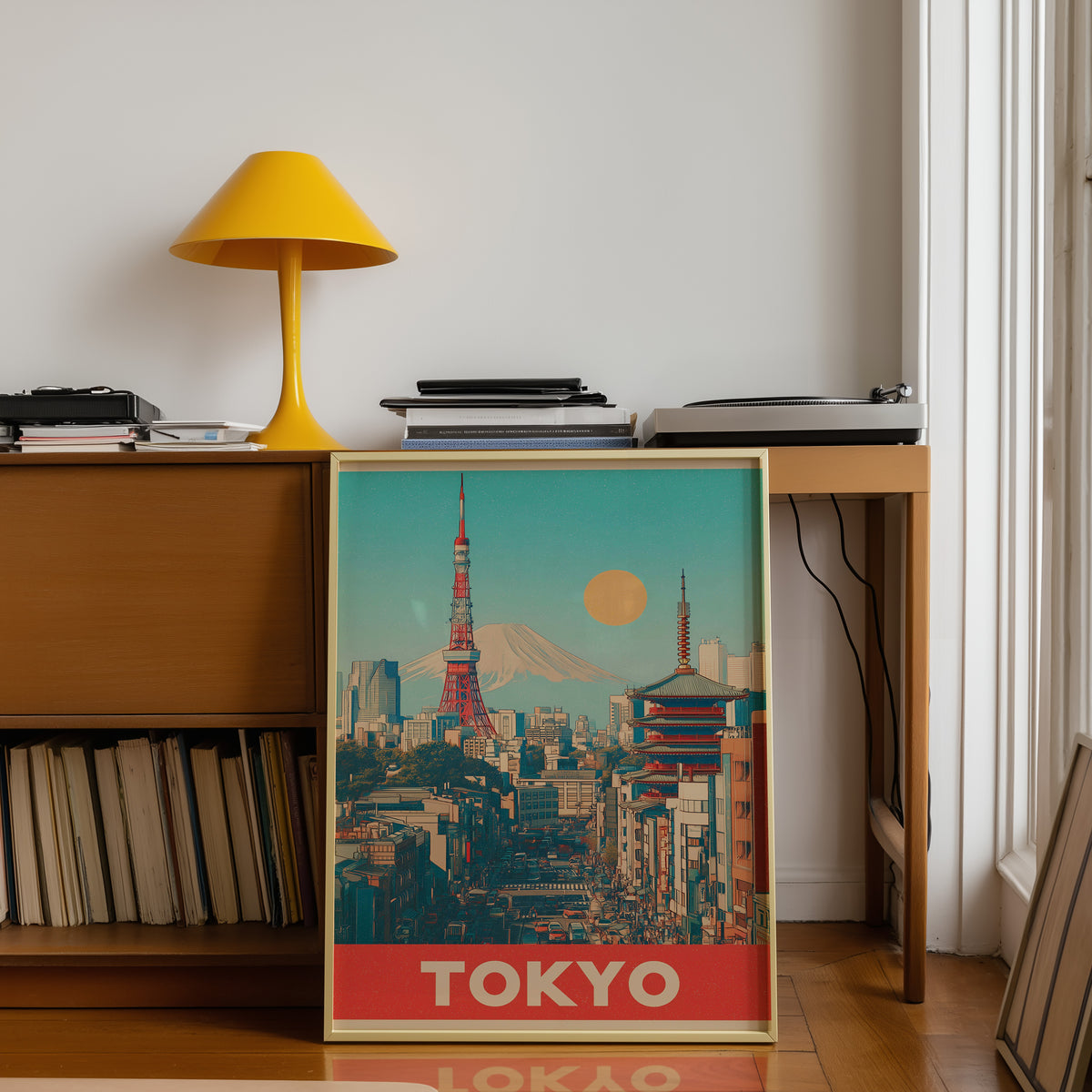 Retro Tokyo Tower and Mount Fuji print shown in a gold frame below a teak desk with a yellow lamp