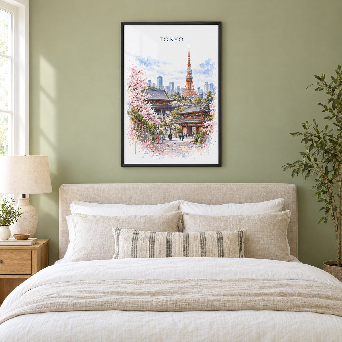 Tokyo watercolor print in a black frame above an upholstered headboard in a sage green bedroom