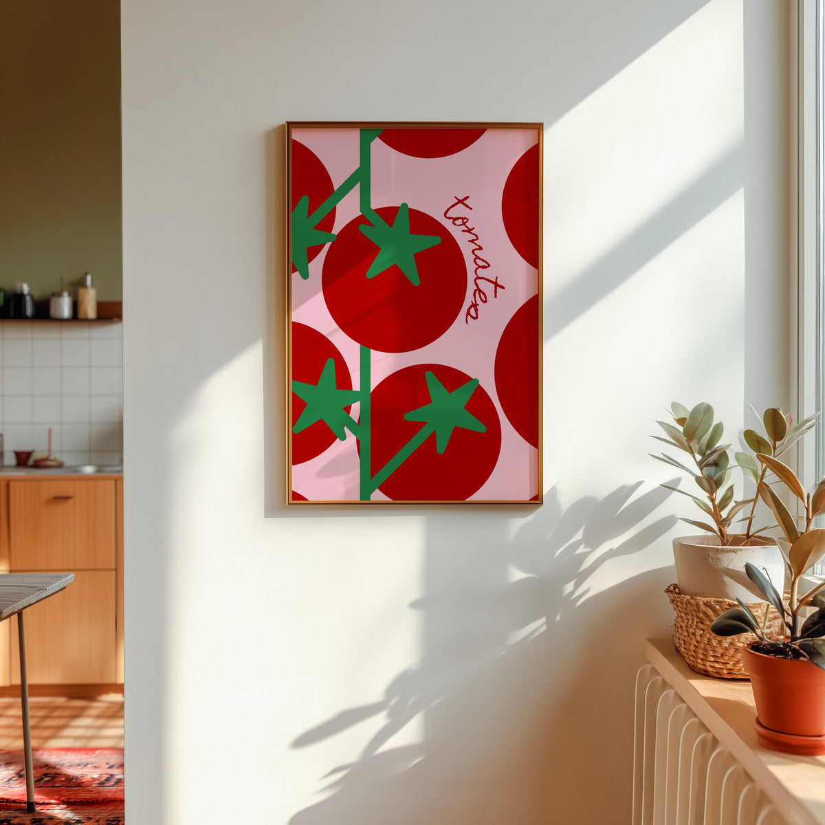 Tomates print in a gold frame in sunlight with plants and a kitchen beyond