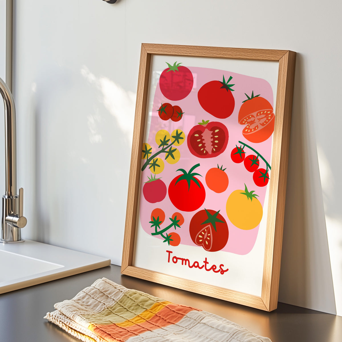 Tomates print in an oak frame by the kitchen sink beside a striped tea towel