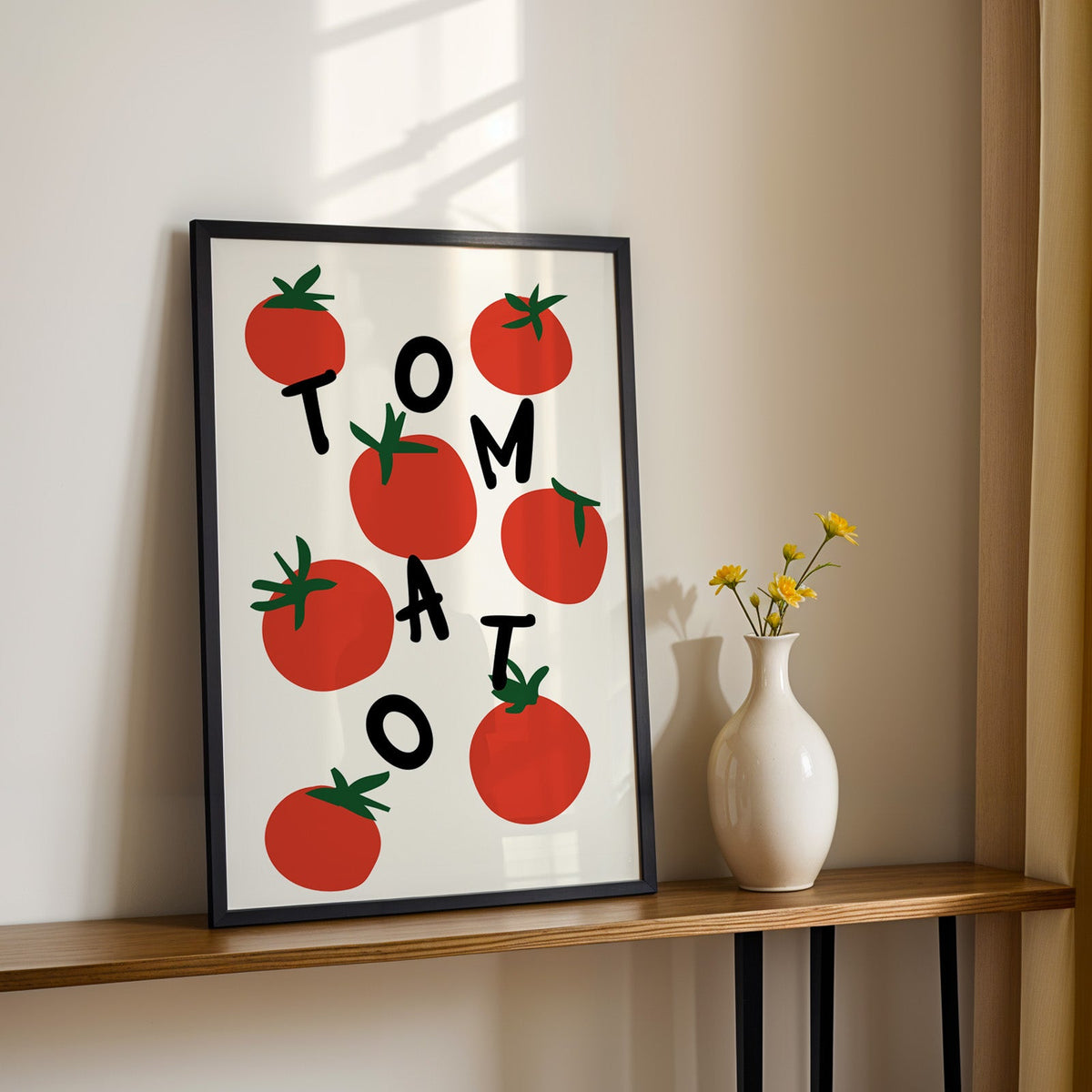 Tomato letters print in a black frame on a console table with yellow daisies