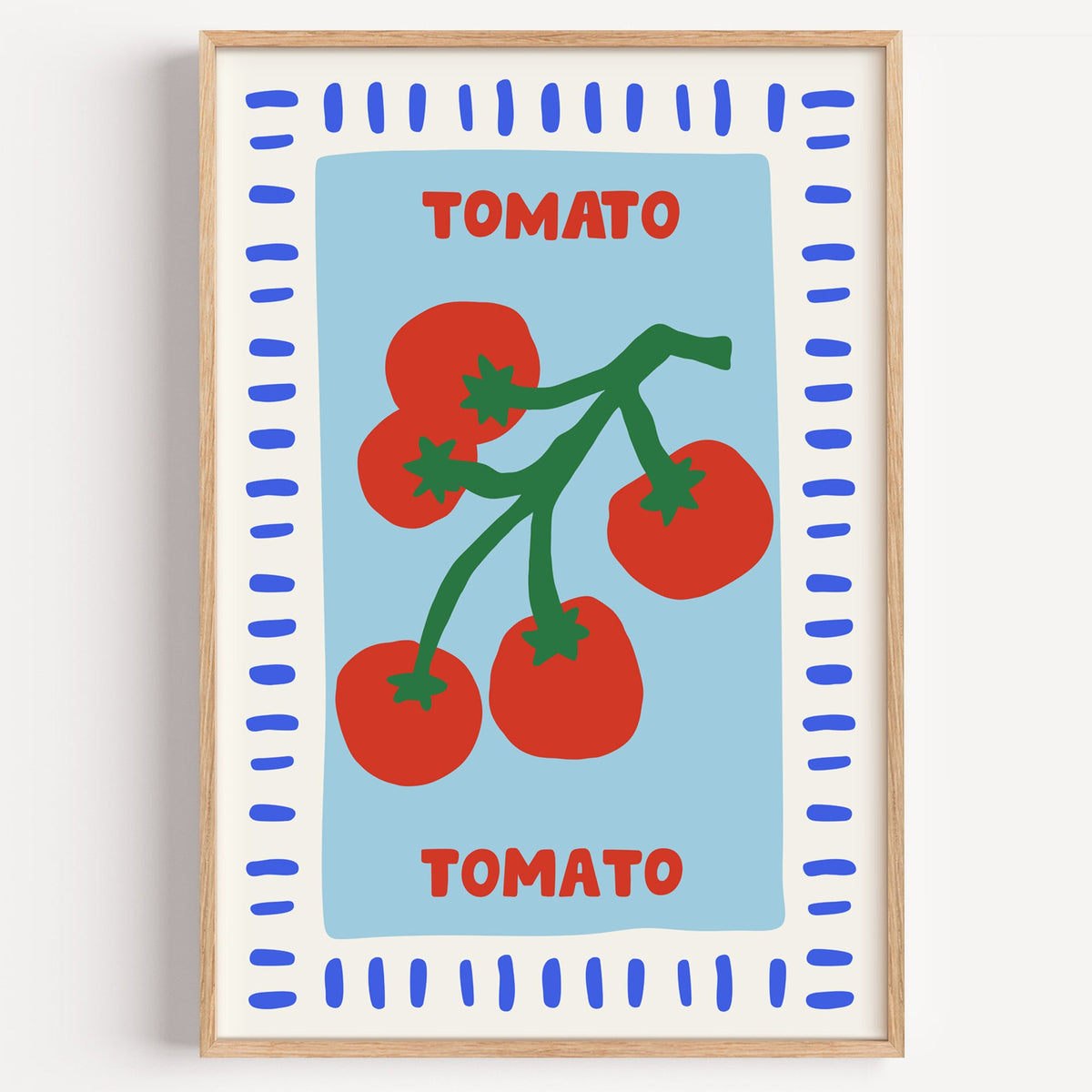 Tomato seed packet print in a light oak frame on a plain white wall