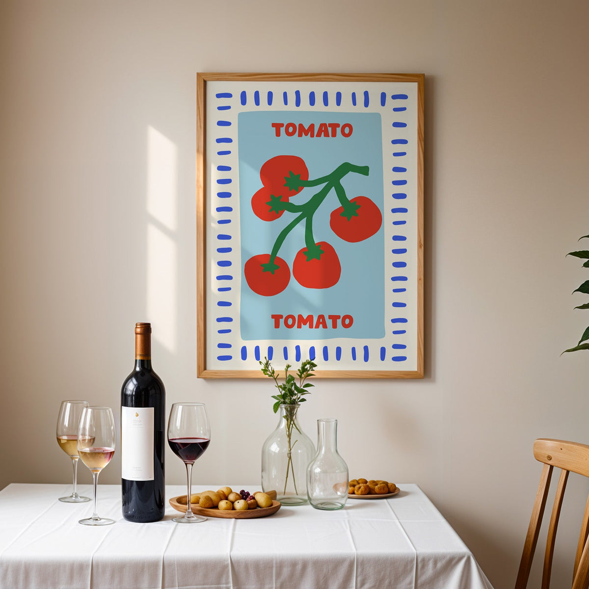 Tomato seed packet print in an oak frame above a table laid with red wine