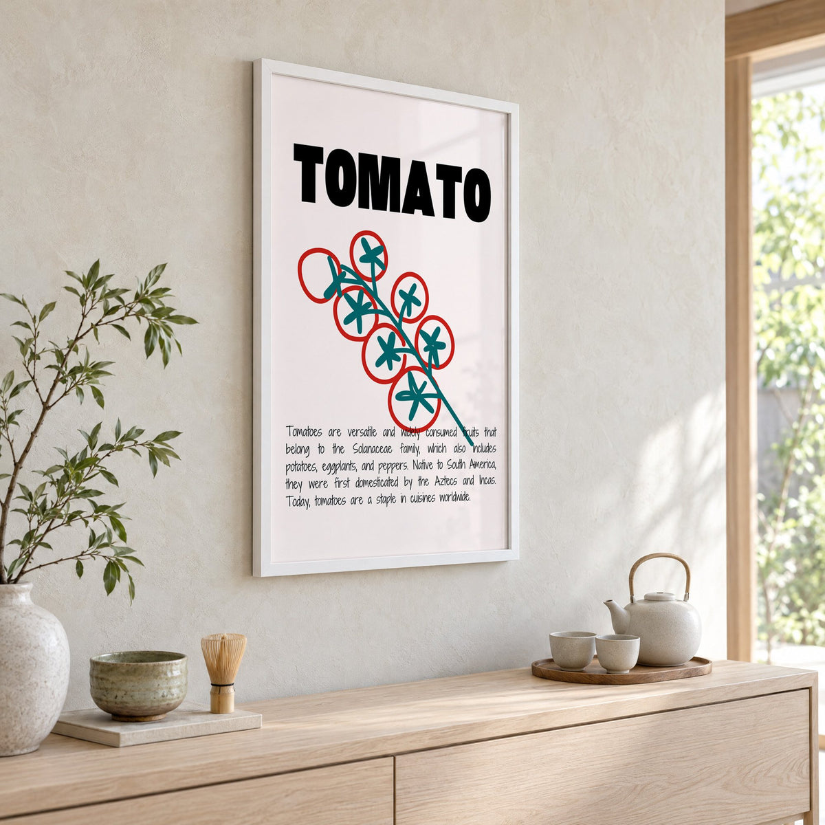 TOMATO bold type tomato vine print in a white frame above a pale wood console with a matcha tea set