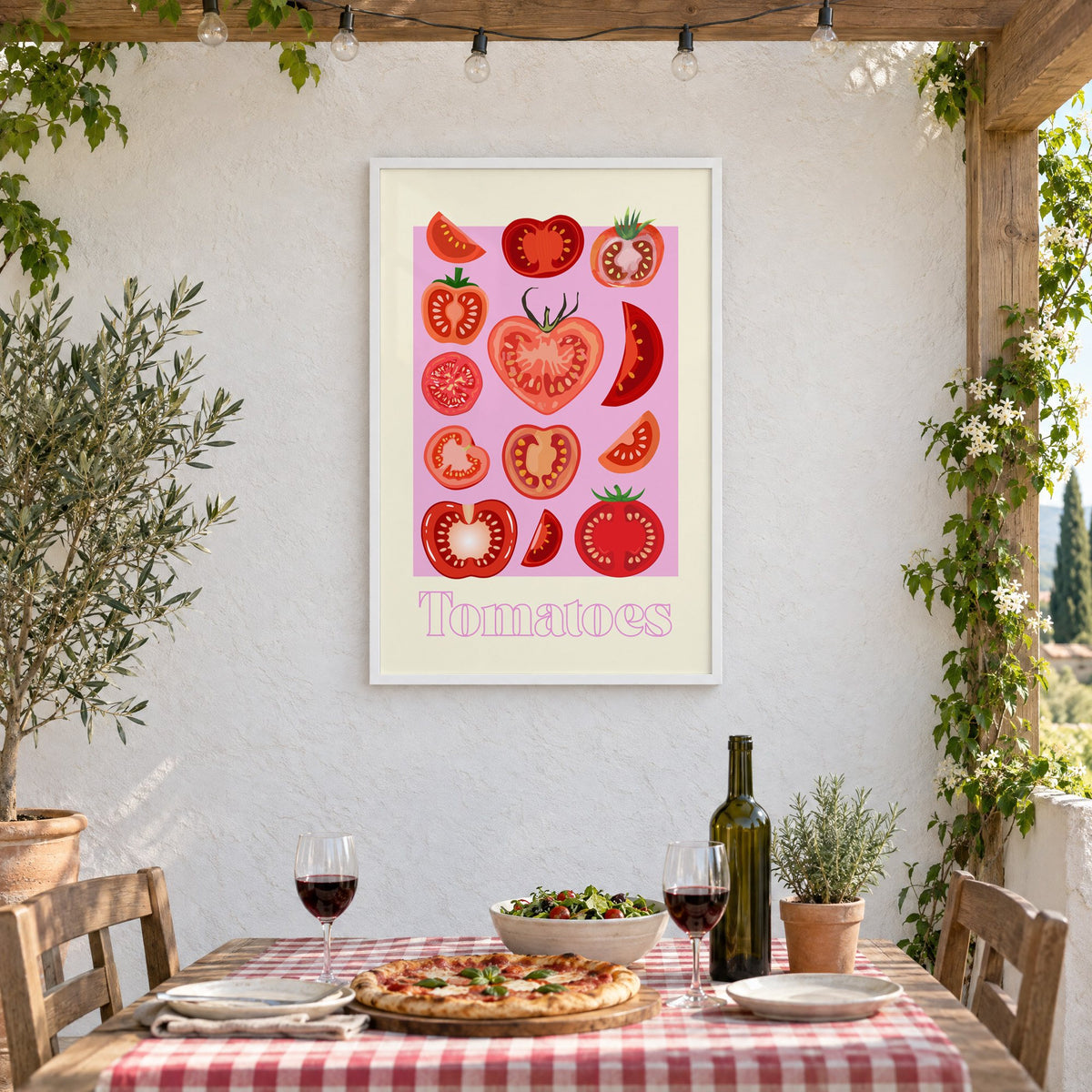 Tomatoes cross sections pink panel print in a white frame on a stucco wall above a checked-cloth table with pizza and red wine