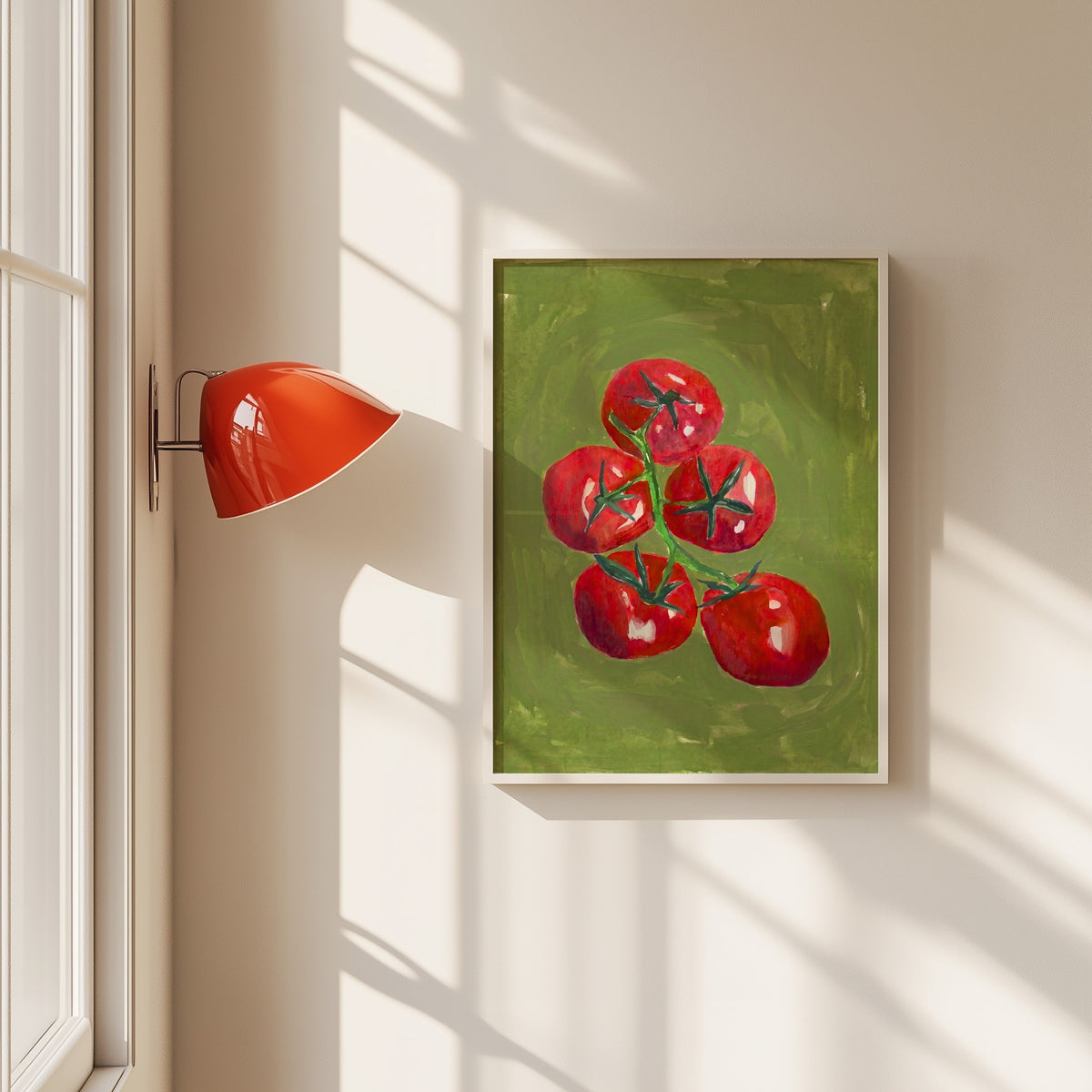 Tomatoes on the vine print in a white frame beside a red wall sconce