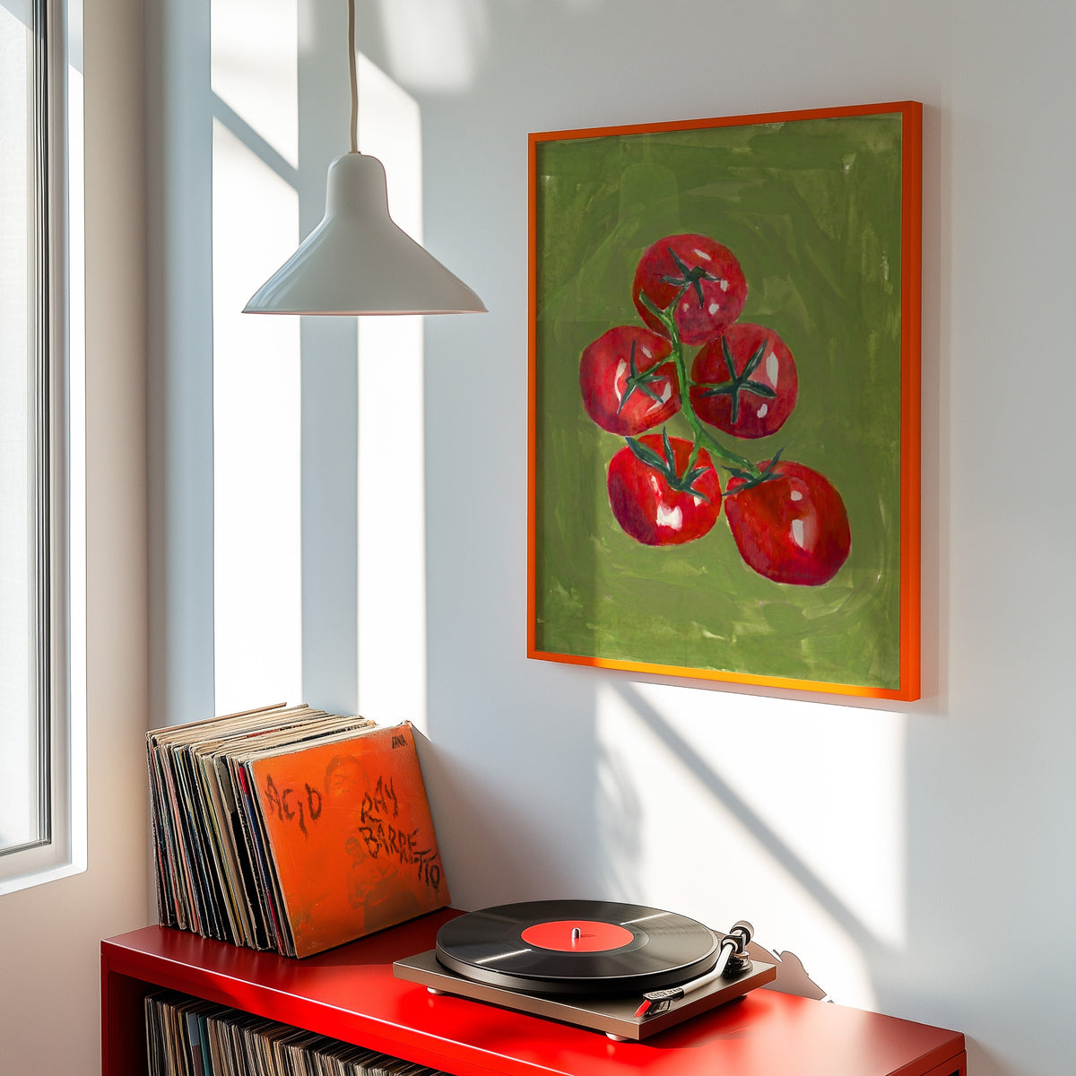 Red tomato kitchen print shown in an orange frame above a red record cabinet and turntable