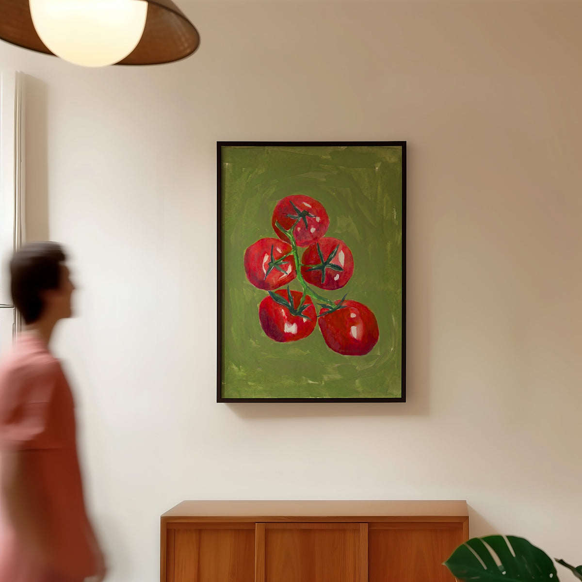 Tomato still life print in a black frame in a hallway under a rattan pendant